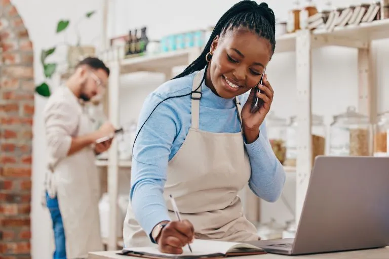 Small business owner in apron with laptop