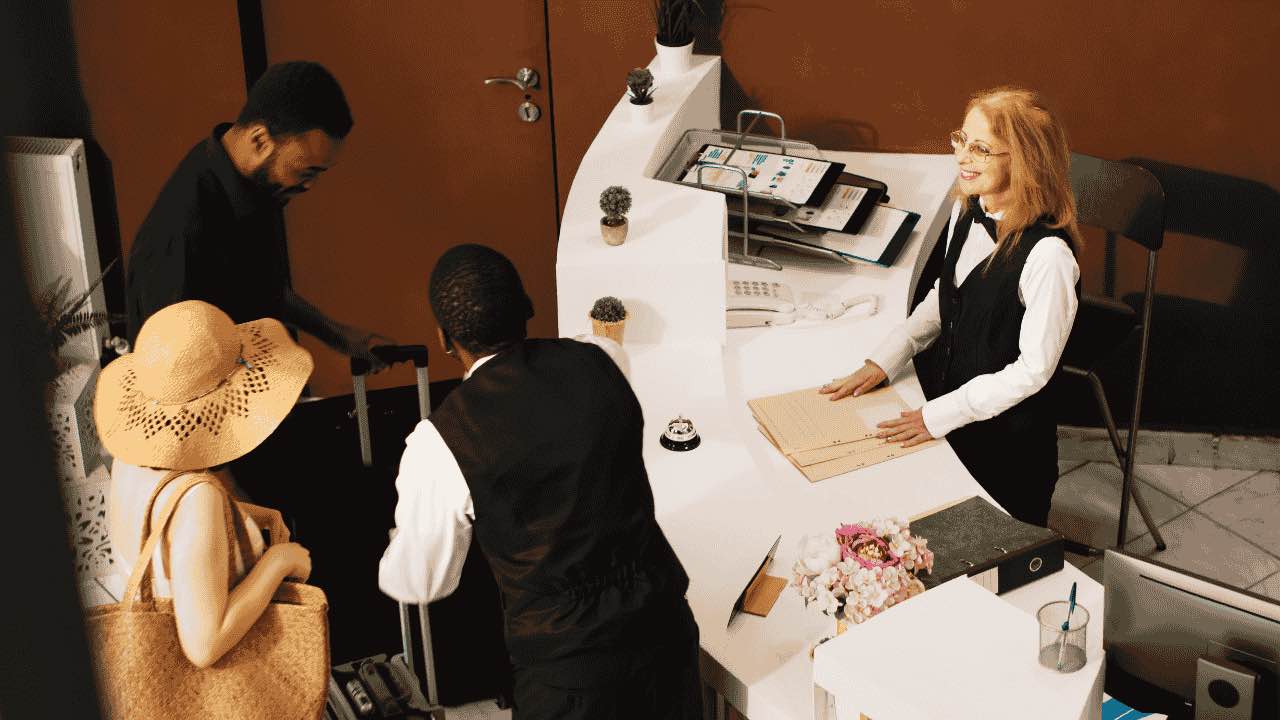 People arriving at hotel front desk